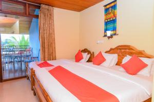 a bedroom with a large bed and a balcony at Blue Haven Hotel in Kandy