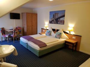 ein Hotelzimmer mit einem großen Bett und einem Waschbecken in der Unterkunft Hotel Flora in Hannover