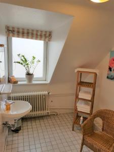 ein Bad mit einem Waschbecken und einem Fenster in der Unterkunft Hotel Flora in Hannover