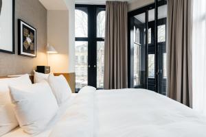 
a bedroom with a large bed and a large window at The Hunfeld in Utrecht
