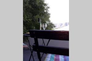 een tafel met een fles wijn en een wijnglas bij Moondust near the ocean, food and wine in Hermanus
