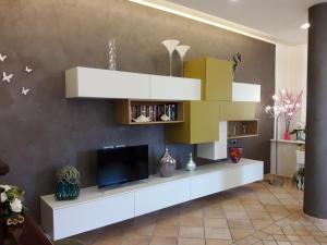 uma sala de estar com uma televisão de ecrã plano e uma prateleira em Hotel Cinzia em Porto Garibaldi