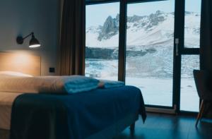 a bedroom with a bed and a view of a mountain at Hótel Kría in Vík