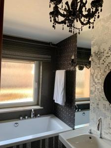 a bathroom with a tub and a sink and a window at Hotel Linder in Malnia