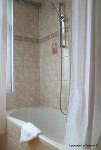 a white bath tub with a shower curtain in a bathroom at Hôtel de l'Univers Liège in Liège