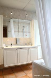 Baño blanco con lavabo y espejo en Hôtel de l'Univers Liège en Lieja