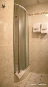 La salle de bains est pourvue d'une douche avec une porte en verre. dans l'établissement Hôtel de l'Univers Liège, à Liège