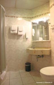 a bathroom with a sink and a toilet and a mirror at Hôtel de l'Univers Liège in Liège