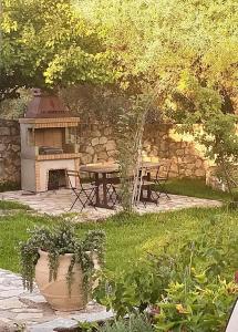 a picnic table in a garden with a stone wall at House of Garden in Dhráganon