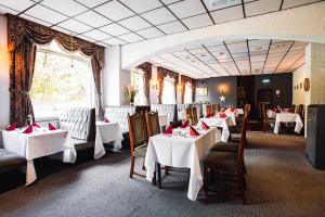 a dining room with tables and chairs with white table cloth at Borough Arms Hotel in Stoke on Trent