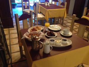 a table with breakfast food on it in a restaurant at Los Abetos B&B 2 in El Bolsón