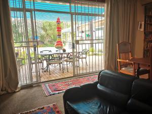プレトリアにあるMeintjieskop Self-Catering Accommodationのリビングルーム(ソファ付)が備わり、パティオの景色を望めます。