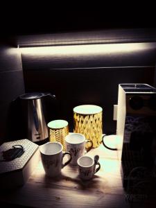tre tazze di caffè sedute su un tavolo accanto a un frullatore di My Monopoli -Casa dei Fiori Suite "Tulipano Nero" Centro Storico a Monopoli