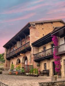 a building with a balcony with purple flowers on it at La Infinita Rural Boutique in Carmona