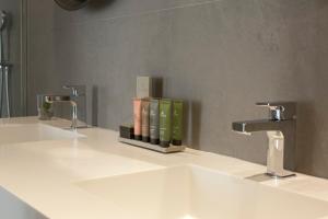 a bathroom with two sinks and two faucets at Teatro Romano 7 & 8 in Málaga +27 photos