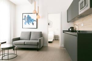 a living room with a couch and a chair at Teatro Romano 7 & 8 in Málaga