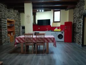 a kitchen with a table and chairs and red appliances at Casa Rural Rio Cabrera in Las Médulas