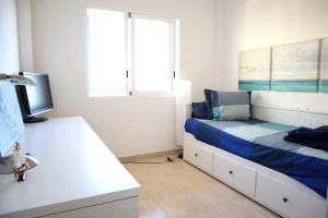 a bedroom with a bed and a desk and window at 2 bed penthouse, Bolnuevo in Bolnuevo