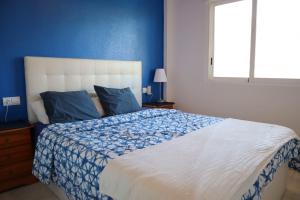 sypialnia z dużym łóżkiem i niebieską ścianą w obiekcie 2 bed penthouse, Bolnuevo w mieście Bolnuevo