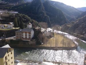 eine Luftansicht auf einen Fluss mit Gebäuden und Bergen in der Unterkunft Nadal Apartaments in Llavorsí