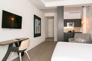 a room with a bed and a desk and a kitchen at Teatro Romano 3 & 6 in M&aacute;laga