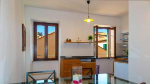 una cucina con tavolo in vetro e alcune finestre di Appartamenti del Grigolo a Portoferraio Altre 20 foto