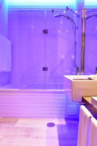 ein Badezimmer mit einer Dusche, einer Badewanne und einem Waschbecken in der Unterkunft Pestana Alvor South Beach Premium Suite Hotel in Alvor