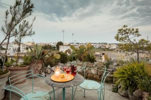 un piccolo tavolo con due sedie e candele sul balcone di Castle XVIII near sea a Gagliano del Capo