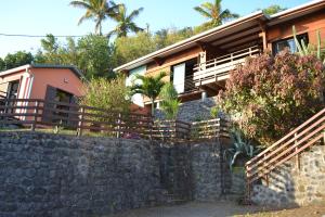 ein Haus hinter einer Steinmauer in der Unterkunft Villa atypique le chat perché de Grand Anse in Petite Île