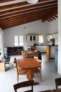 ein Wohnzimmer mit einem Tisch und einer Küche in der Unterkunft Hostel Le Chandelier in Saint-Ursanne