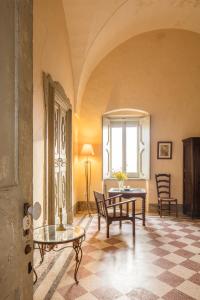 ein Wohnzimmer mit einem Tisch, Stühlen und einem Fenster in der Unterkunft Castle XVIII near sea in Gagliano del Capo