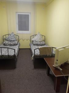 ein Krankenhauszimmer mit 2 Betten und einem Tisch in der Unterkunft Хостел АС Рахів in Rachiw