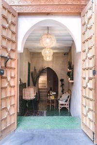 馬拉喀什的住宿－Riad BE Marrakech，拱门通往带桌椅的房间