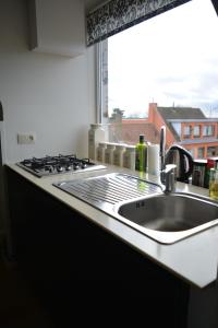 a kitchen counter with a sink and a window at Maison Anna Clara in Nieuwpoort