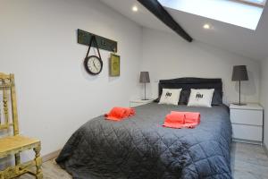 ein Schlafzimmer mit einem großen Bett mit zwei orangenen Kissen in der Unterkunft Casa da Escola in Cacia