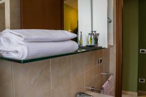 a white towel hanging on a towel rack in a bathroom at Residenze Santa Costanza in San Vincenzo