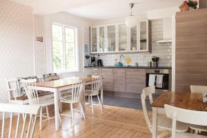 a kitchen and dining room with a wooden table and chairs at Malmgårdens vandrarhem B&B in Strängnäs