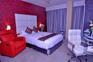 a bedroom with a bed, chair, lamp, and a dresser at Contemporary Heights Hotel and Apartments in Dhaka