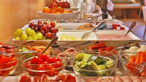 a buffet of food with bowls of fruit and vegetables at Businesshotel HEILBRONN- Biberach in Heilbronn