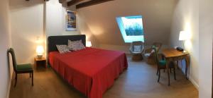 1 dormitorio con cama roja, mesa y sillas en Bed & Brockhof Meerbusch, en Meerbusch