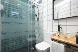 W łazience znajduje się toaleta i przeszklony prysznic. w obiekcie Loft en Triana w Sewilli
