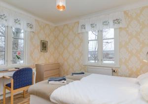 1 dormitorio con 2 camas, escritorio y ventanas en Malmgårdens vandrarhem B&B, en Strängnäs