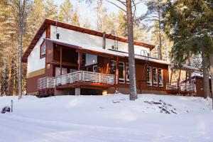 une maison dans la neige dans les bois dans l'établissement Kolin Lotus Cottages, à Kolinkylä