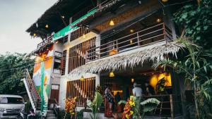 un edificio con gente parada fuera de él en Hang Loose Hostel, en General Luna