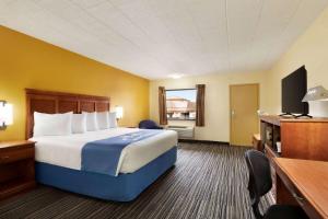 Un pat sau paturi într-o cameră la Days Inn by Wyndham Oak Ridge Knoxville