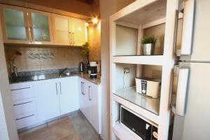 uma pequena cozinha com armários brancos e um frigorífico em Octopus Apartment - Lagoon Villa em Dahab