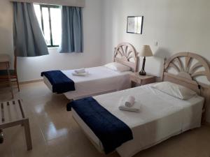 a hotel room with two beds with towels on them at Dunas 107 in Alvor