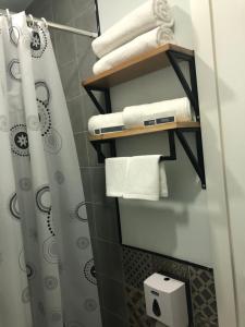 a bathroom with towels and a shower curtain at In City Hotel in Yerevan
