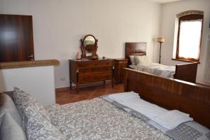 1 Schlafzimmer mit 2 Betten, einer Kommode und einem Spiegel in der Unterkunft VILLA CLANI apartment in Colà di Lazise