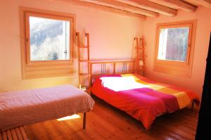sypialnia z 2 łóżkami piętrowymi i 2 oknami w obiekcie Agriturismo Corte del Maso w mieście Bassano del Grappa